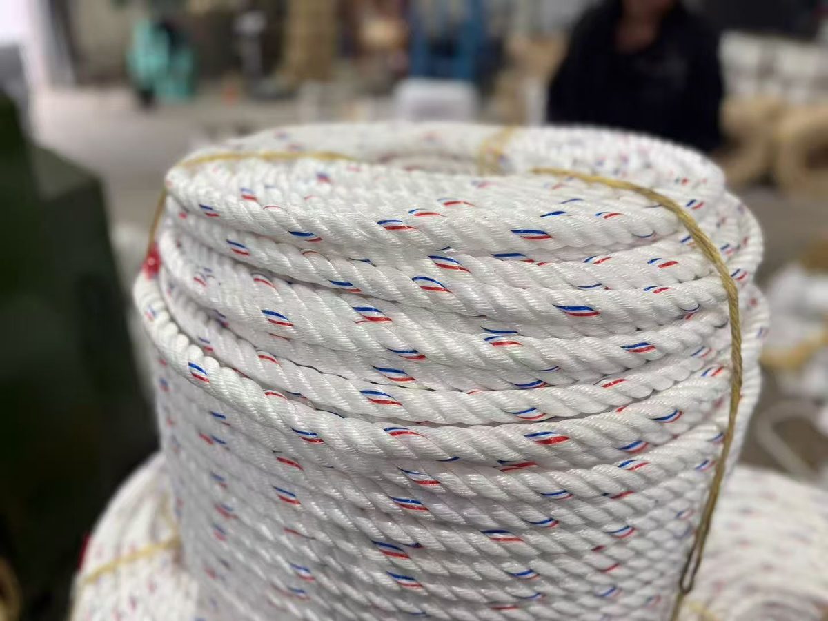 Close-up of white 3-strand twisted PE rope with red and blue tracer strands laid into the strands