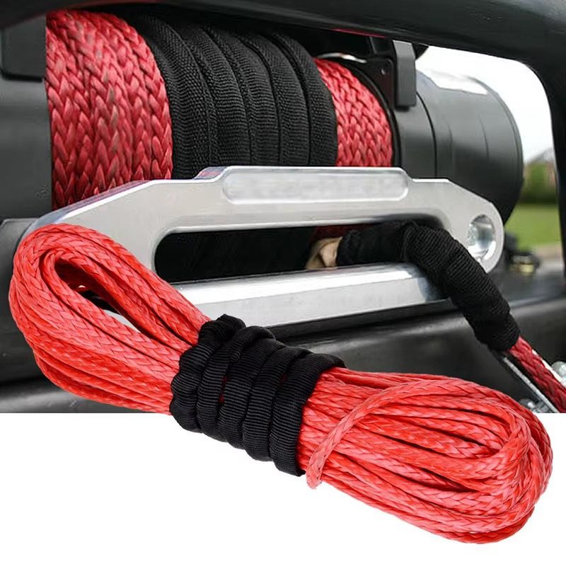 Red UHMWPE 12-strand winch rope installed on a vehicle winch, with aluminium hawse fairlead and black protective sleeve at the hook end
